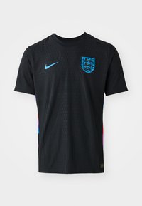 Black Nike t-shirt with a textured pattern, featuring a blue emblem with three lions and multicolored accents on the sides. Short sleeves.