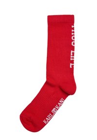 Röda bomullsribbade strumpor med vit "KARL KANI" text och "THOOO LIT" mönster längs sidan. Mellanlängd och standardpassform.