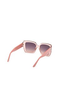 Lunettes de soleil carrées avec une monture rose clair et des verres dégradés. Les branches sont à motifs et se terminent par un accent en métal poli.