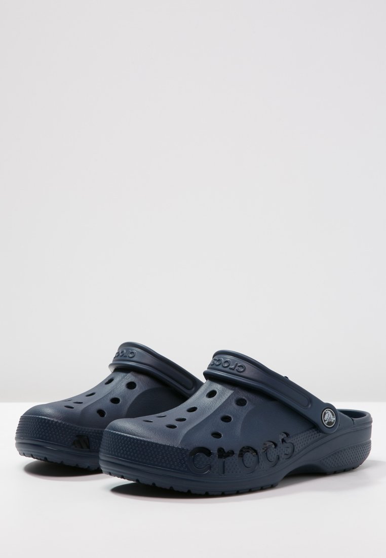 Ciabatte Crocs di colore blu navy, realizzate in materiale schiumoso, con fori di ventilazione, una fascia posteriore e logo del marchio impresso su un lato.