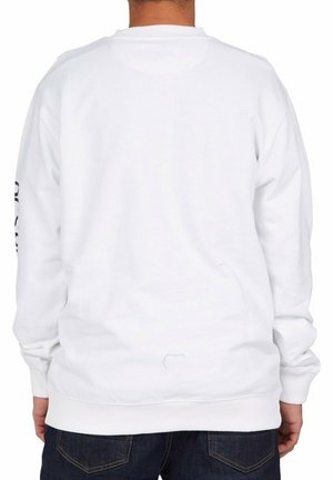 Biała bluza z długimi rękawami, okrągłym dekoltem, gładkim tyłem i ściągaczami na rękawach. Tkanina wydaje się miękka z delikatną fakturą. Brak widocznego nadruku lub wzoru.