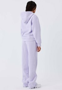 Lila sweat hoodie met een kangaroezak en geribbelde mouwen, gecombineerd met bijpassende wijde sweatpants van zachte stof. De hoodie heeft een trekkoord.