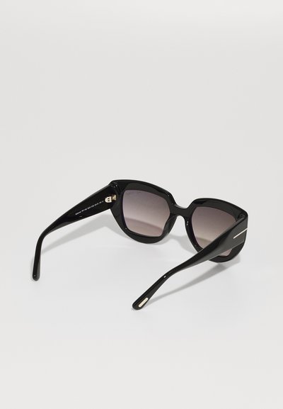 Occhiali da sole neri con montatura angolare e lenti graduali. Presentano aste nere eleganti, dettagli in oro e una finitura lucida e liscia.