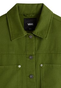 Giacca di jeans verde con colletto, due tasche sul petto e bottoni a pressione argentati. L'etichetta mostra il marchio "Vans" e la taglia "Piccola."
