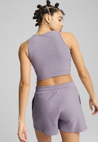 Lavendelkleurige ribgebreide croptop in combinatie met bijpassende shorts; beide hebben een zachte textuur en een elastische tailleband met zijzakken.