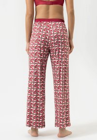 Un pantalon de pyjama à motifs rouges et blancs avec une taille élastique ; présente des pois ronds en forme de grille dans les tons rouge, gris et noir.
