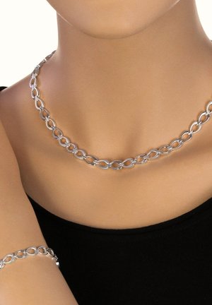 Silver chain necklace with oval links and matching bracelet. Smooth texture and shiny finish. Displayed on a neutral background.