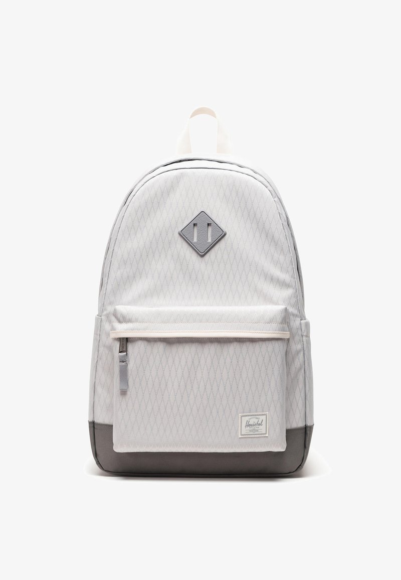 Sac à dos gris clair avec motif en losanges, fermeture éclair blanche et fond gris foncé. Comprend une poche avant et une étiquette avec le logo Herschel.