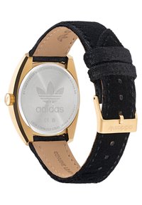Aukso atspalvio nerūdijančio plieno laikrodis su juodu zefyro dirželiu. Yra apvalus korpusas ir išgraviruota adidas logotipas ant nugaros. Autentiška odinė pamušalas.