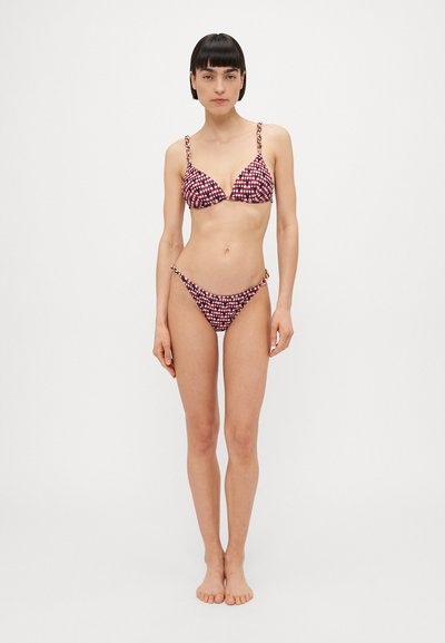 Conjunto de bikini com padrão em vermelho e azul marinho, com alças ajustáveis, detalhes metálicos e formato triangular em uma textura lisa.