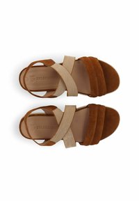 Braune Wildleder-Sandalen mit einem breiten Riemendesign und beigen elastischen Bändern. Verfügt über eine flache Sohle und dezente Markenkennzeichnung auf der Innensohle.