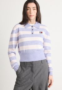 Pulover tricotat cu dungi lila și roz, cu guler și închidere cu trei nasturi. Marginile și manșetele ribbate; mic logo pe pieptul stâng.