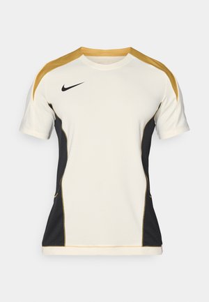 T-shirt sportivo bianco con pannelli laterali neri e dettagli dorati, caratterizzato da una texture in rete e maniche corte, progettato per l'abbigliamento atletico.