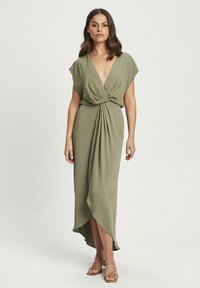 Olive green dress with a deep v-neck and short flutter sleeves, featuring a twisted waist detail and an asymmetrical hemline.