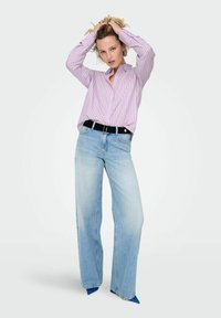 Chemise à rayures violettes claires avec boutons, jean large taille haute bleu clair, ceinture noire et escarpins pointus bleus. Texture de tissu lisse.