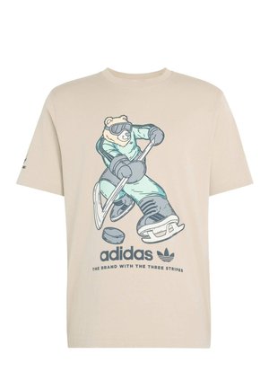 Beige bomulls-t-shirt med en tecknad björn i hockeyutrustning, med klubba, puck och Adidas-logotyp i mörkblått. Klassisk rund halsringning.