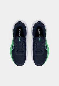 Marine treningssko med teksturert stoffoverdel, grønne detaljer, hvit mellomsåle og svarte lisser. Logo synlig på tungen.