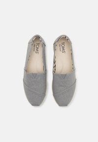 Šedé plátěné slip-on boty s kulatou špičkou a elastickými bočními akcenty, s vzorovanou stélkou a texturovaným vnějším materiálem.