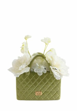 Grøn quiltet håndtaske med guldspænde holder hvide blomster med sarte kronblade og tynde stilke.
