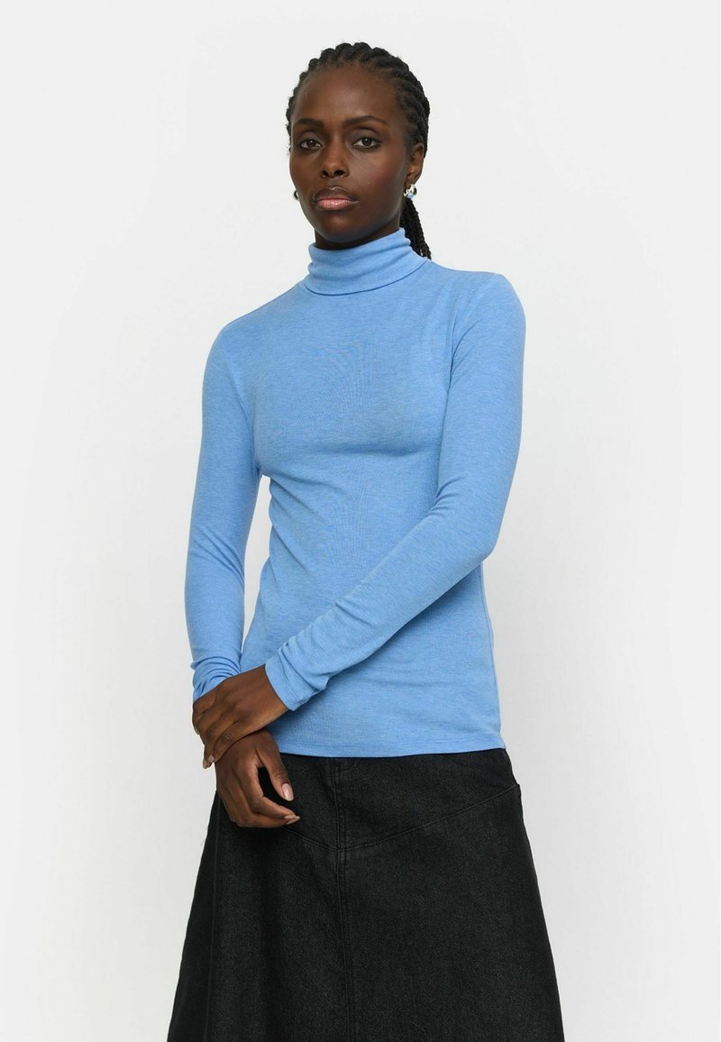 Blaues Langarm-Turtleneck-Oberteil aus glattem Stoff, kombiniert mit einem schwarzen Rock. Das Turtleneck hat ein figurbetontes Design und ist dehnbar.