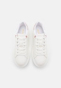 Weiße Sneakers mit einem glatten Leder-Obermaterial, runder Zehenpartie, flachen weißen Schnürsenkeln und hellrosa Akzenten an der Ferse. Strukturiertes Gummi-Sohlenmaterial.