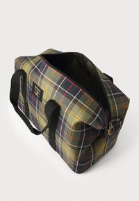 Rectangular plaid tote bag with green, yellow, red, and white lines, black handles, open zipper, and Barbour logo patch on side.