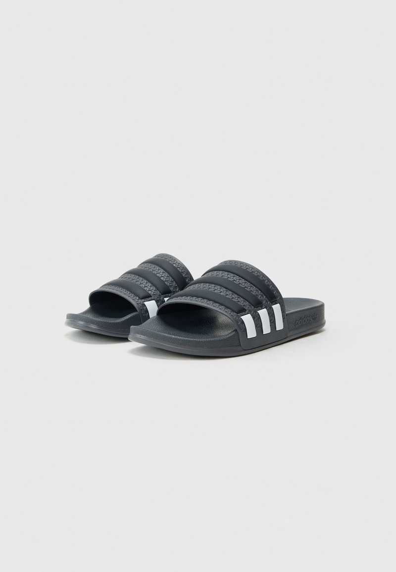 Sandales à glissière gris foncé avec trois brides texturées et accents blancs. Fabriquées en matière synthétique, dotées d'une semelle plate et d'un design ergonomique.