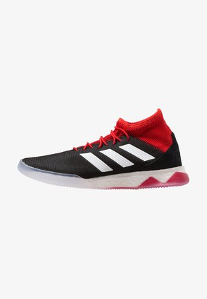 Chaussure de sport montante noire et rouge avec logo blanc à trois bandes, lacets rouges et semelle blanche rembourrée avec accent rouge sur fond blanc.