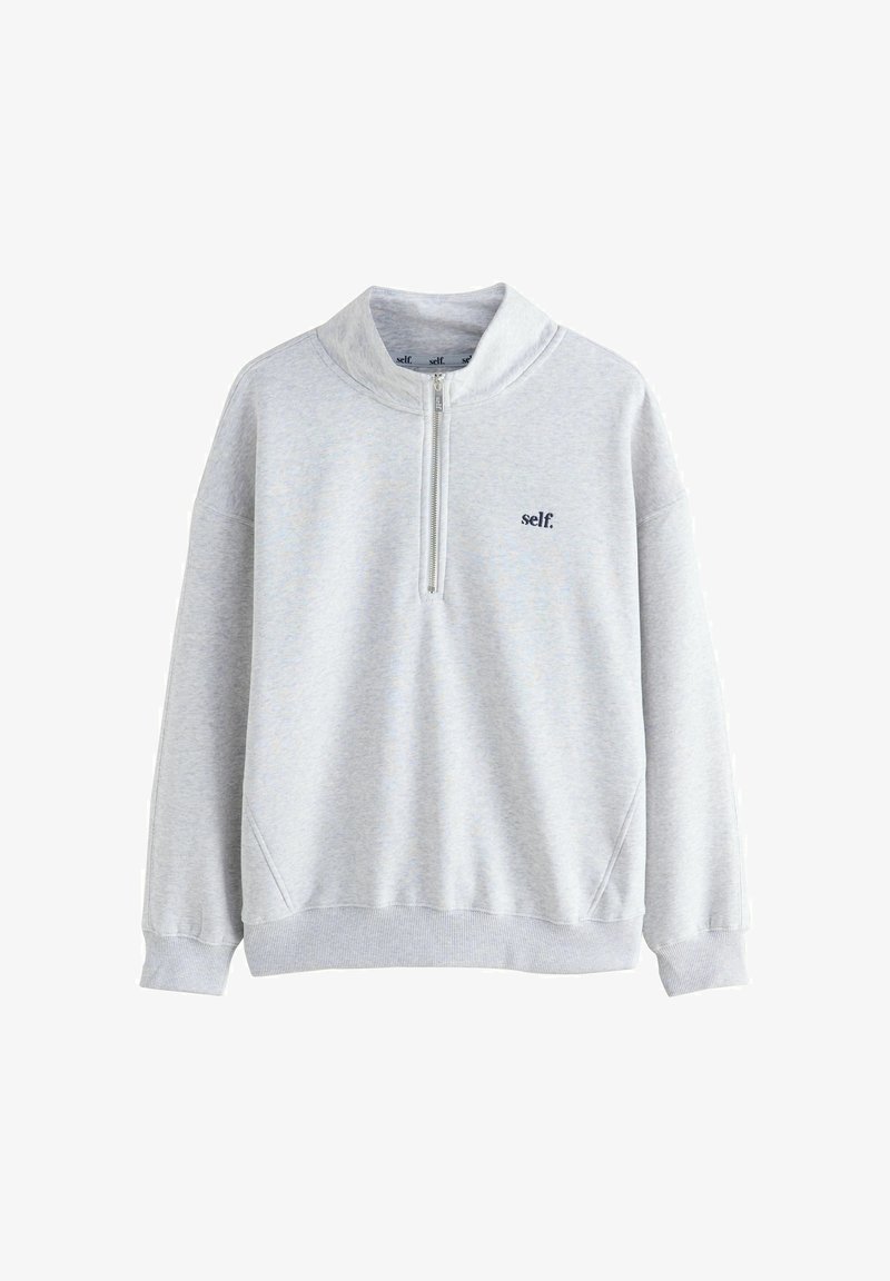 Světle šedý svetr s čtvrtzipem, s žebrovanými manžetami a lemem, se zmenšeným černým textem "self." na levé hrudi.