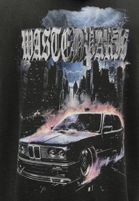 Melna grafiskā t-krekls ar stilizētu automašīnas, liesmu un pilsētas ainavas ilustrāciju. Teksts "WASTED PARK" treknā, stilizētā fontā.