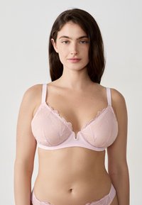 Roze kanten bh met gegolfde randen en een V-vormig middenstuk. Voorzien van delicate bloemborduursels en verstelbare bandjes.