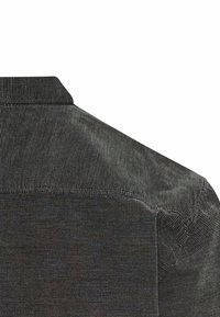 Mørkegrå fløjlskjorte med et struktureret ribbet mønster, der har krave og skuldersømme. Stoffet har en let glans.