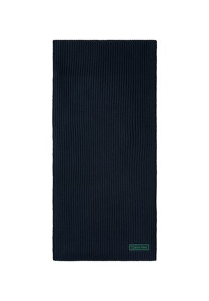 Donkerblauwe geribbelde gebreide rechthoekige sjaal met een klein groen Calvin Klein-logo labeltje, genaaid dicht bij de onderkant op een witte achtergrond.
