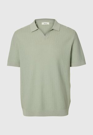 Világoszöld rövid ujjú kötött galléros póló texturált függőleges mintával, V-nyakú gallérral, egyszínű háttéren.