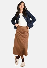 Denim jacket, white shirt, brown suede midi skirt, paired with white and burgundy sneakers and dark brown socks, with minimal stitching details.