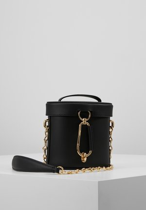 Schwarze zylindrische Tasche aus glattem Leder mit goldenen Beschlägen, einem Obertragegriff, einer Kettenriemen und einem auffälligen Verschlussdetail.
