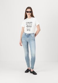 Tommy Jeans NORA - Kitsa lõikega teksad - denim light