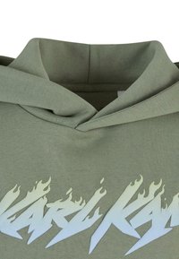 Zielona bawełniana bluza z kapturem z dużym białym graficznym wzorem w kształcie płomienia na przodzie. Posiada regulowany kaptur i miękką teksturę.