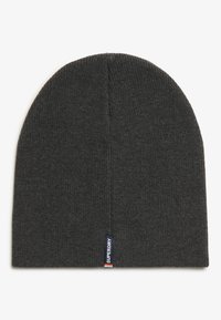 Gorro de punto gris con una textura acanalada, parte superior redonda y una pequeña etiqueta de marca en el borde. Diseño flexible y cálido.