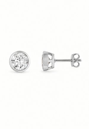 Une paire de boucles d’oreilles puces en argent, ornées de pierres rondes, transparentes et facettées, serties en clos, présentées de face et de profil sur fond blanc.