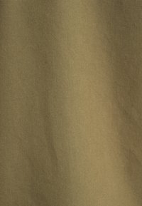 Tessuto in cotone verde oliva, caratterizzato da una texture liscia e un motivo a trama diagonale. Il materiale è durevole e adatto a varie applicazioni.