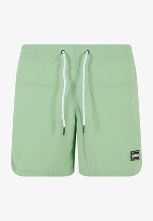 Light green swim shorts made of lightweight fabric, featuring a drawstring waist with white cords and a small black brand logo patch.