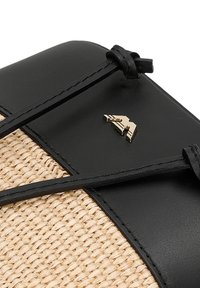 Borsa nera in ecopelle e paglia intrecciata con logo in tono oro e lacci in pelle. Il design combina materiali lisci e texture.