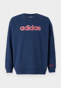 Mörkblå tröja med rund halsringning och långa ärmar, röd och vit "adidas" logotyp centrerad på bröstet, mindre logotyp på vänster ärm. 
