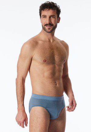 Blaue gemusterte Herrenunterhosen aus strukturiertem Stoff mit einem einfarbigen blauen Bund. Die Passform ist eng und betont die Körperform.