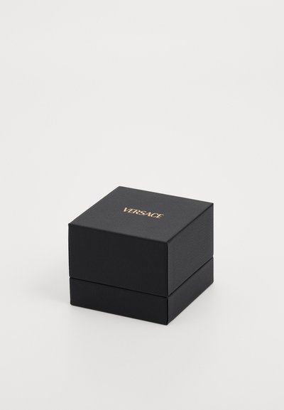 Must mustriga kinkekarp musta tekstuuriga, mille peal on kuldne "VERSACE" logo, ruudukujuline ja lihtsa, voolava disainiga.