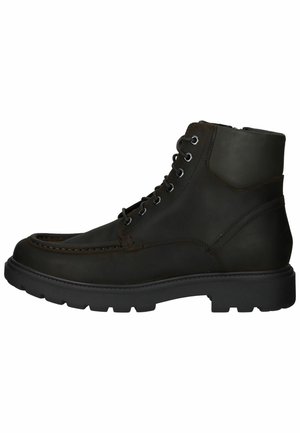 Stivale ankle in pelle nera con punta arrotondata, suola robusta e cuciture decorative. Presenta occhielli metallici e una tomaia liscia per supporto.
