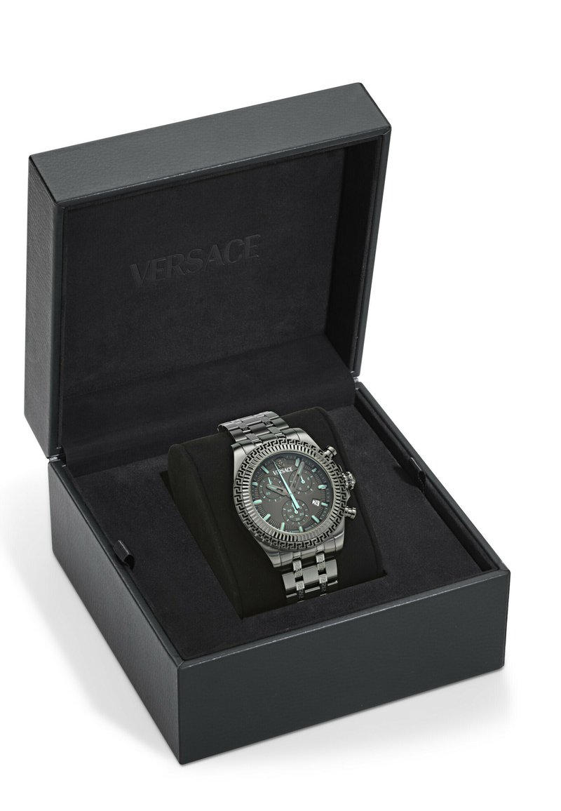 Orologio cronografo in acciaio inox Versace con quadrante nero e bezel decorato, esposto su un cuscinetto nero all'interno di una scatola nera Versace.
