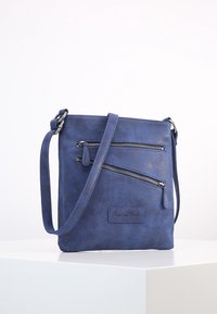 Modrá kabelka přes rameno z umělého semiše se dvěma předními kapsami na zip, plochým obdélníkovým tvarem a nastavitelným popruhem pro snadné nošení.