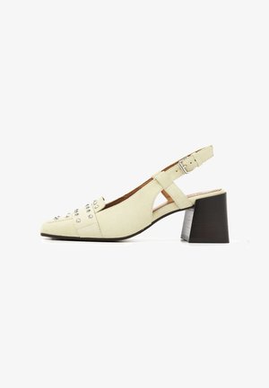Beiger Wildleder-Slingback-Schuh mit Blockabsatz, Knöchelriemen mit Schnalle und dekorativen silbernen Nieten im Zehenbereich.